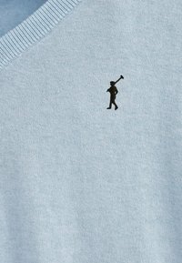 Ljusblått stickat tröja med v-ringning. Har en liten svart broderad figur-logotyp på bröstet. Mjuk textur och medium vikt.