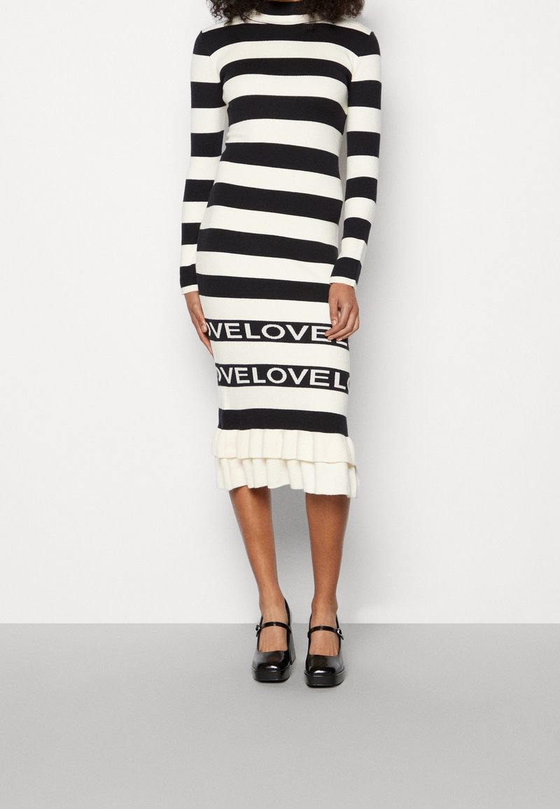 Musta-valkea raitapaita, jossa on pitkät hihat, röyhelöhelma ja "LOVE" -painatus alaosassa.