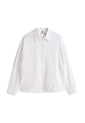Wit overhemd met lange mouwen en knopen, met kraag, eenvoudig ontwerp en een subtiel gestreept label aan de binnenkant van de kraag, weergegeven op een witte achtergrond.