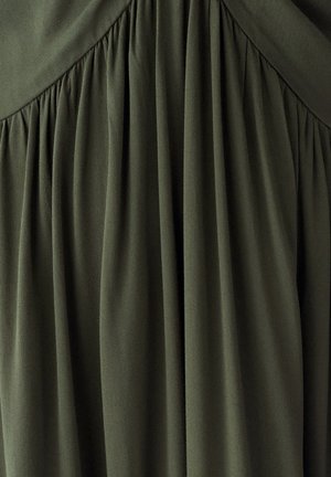 Tissu vert olive foncé avec des plis froncés et un détail de couture en forme de chevron près du centre supérieur.
