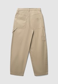 Beige weite Hose mit zwei aufgenähten Gesäßtaschen, Gürtelschlaufen, zusätzlicher Seitentasche und lässiger Passform, von hinten gezeigt.