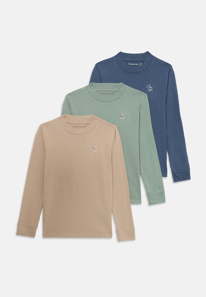 Drei Langarm-T-Shirts: hellbeige, mintgrün und marineblau. Jedes verfügt über ein kleines gesticktes Reh-Logo auf der Brust. Aus weichem Baumwollmaterial.