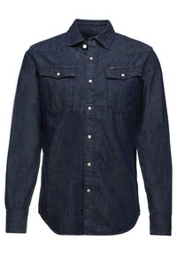 Camisa de manga larga de denim azul oscuro con cierre de botones en la parte frontal, dos bolsillos en el pecho con solapa y cuello clásico, estilo ajustado.