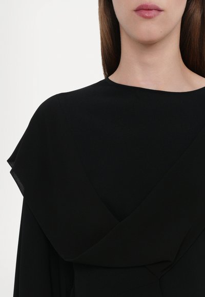 Black dress featuring a draped neckline with layered fabric, smooth texture, and a fitted silhouette, highlighting clean lines and minimal design.