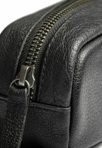 Černá kožená taška s strukturovaným povrchem, zipem se stříbrným kováním a obdélníkovým tvarem.