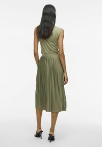 Vestito midi plissettato in morbido tessuto verde oliva, con corpino aderente e gonna fluida. Texture liscia con dettaglio in vita arricciata.