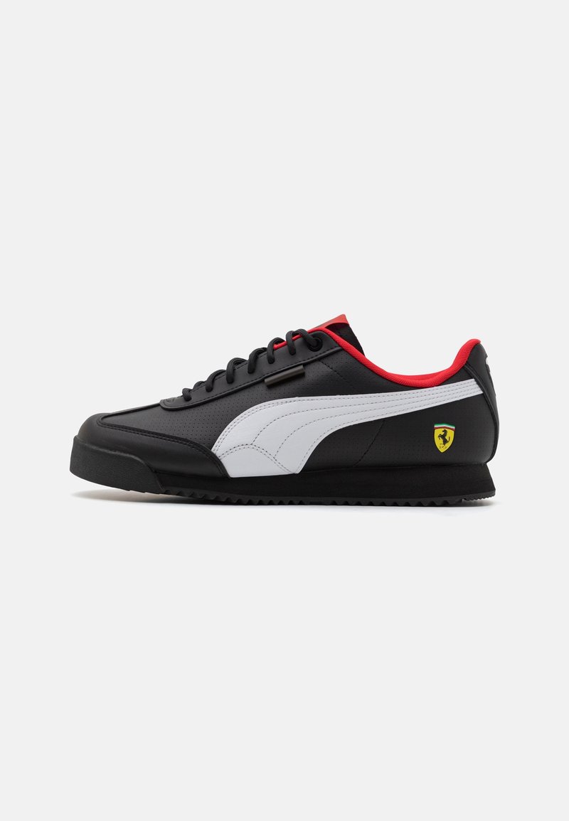 Baskets Puma noir et blanc avec doublure intérieure rouge et logo Ferrari sur le talon, montrées en profil latéral sur fond blanc.