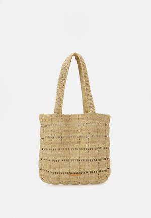 Beżowa pleciona torba na ramię z dwoma uchwytami, z otwartym, przewiewnym wzorem szydełkowym oraz małą prostokątną etykietą blisko dolnego środka.