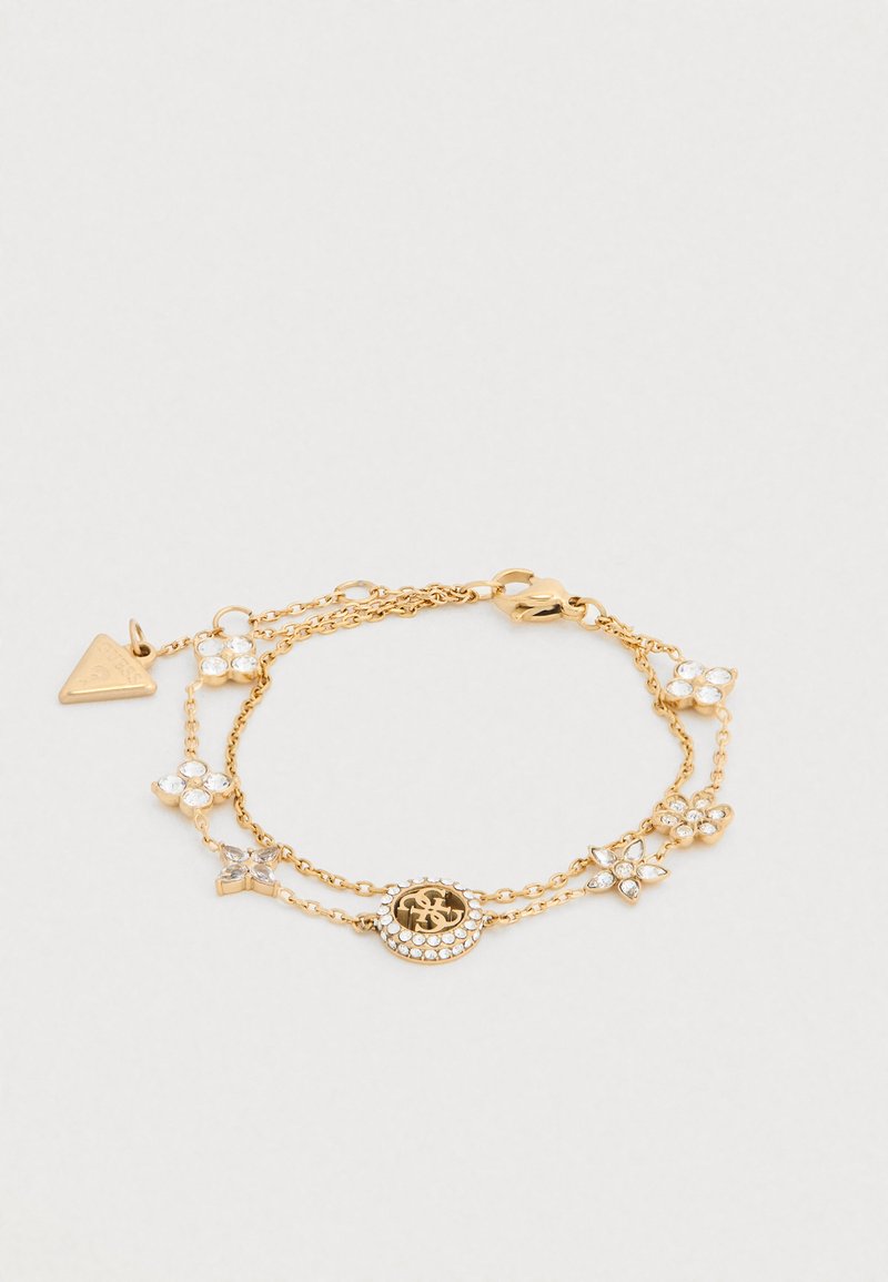 Βραχιόλι πολλαπλών σειρών σε χρυσό με λουλουδένιες λεπτομέρειες, στρας και στρογγυλό μενταγιόν. Περιλαμβάνει τριγωνική ταμπελίτσα και κούμπωμα τύπου αστακός.