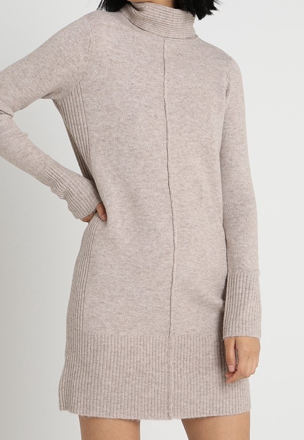 Robe-pull en tricot beige avec poignets, ourlet et côtés côtelés, dotée d'un col montant haut et d'une couture centrale.