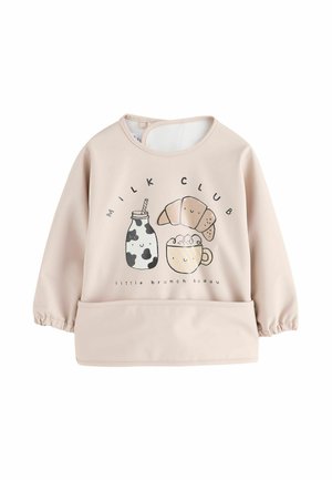 Beige long-sleeve baby bib with elastic cuffs and pocket, featuring cute illustrations of milk bottle, croissant, and cup with the text "Milk Club."