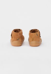 Braune Wildleder-Stiefeletten mit einem Klettverschluss, glatter Gummisohle und buntem Dekostich.
