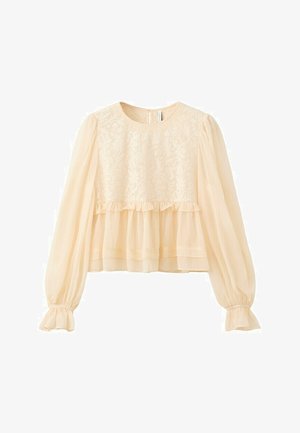 Blouse longue à manches longues crème avec corsage en dentelle, manches bouffantes transparentes, couture à la taille à volants et poignets élastiqués.