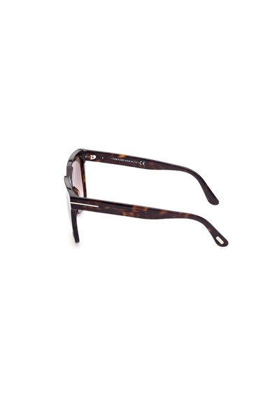 Lunettes de soleil écaille de tortue avec des verres foncés, présentant une monture épaisse, des branches fines et des accents en argent sur les tempes. Fabriquées en Italie.