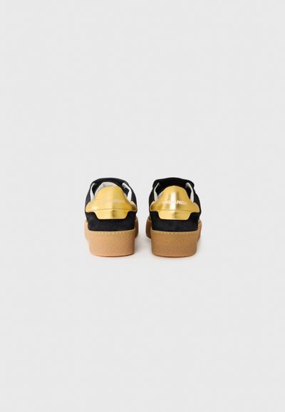 Black suede platform shoes featuring a gold metallic heel accent and beige rubber sole. Designed with a slip-on style and minimal detailing.