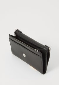 Portafoglio in pelle nera con una texture liscia, chiusura a cerniera e bottone a pressione. Presenta una forma sottile e rettangolare con più scomparti.