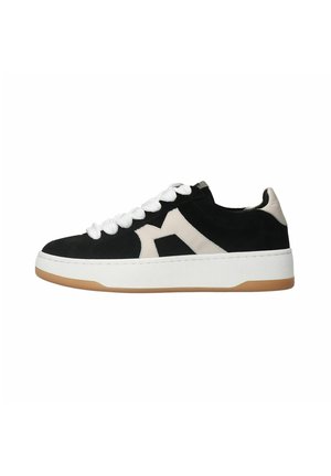 Zwart-witte sneaker met een bovenkant van suede, voorzien van een contrasterende beige accent, witte veters, een dikke witte tussenzool en een gumrubberen buitenzool.