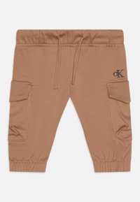 Pantalons cargo en coton marron avec une taille élastique, un cordon de serrage et des poches latérales. Présente un petit logo brodé à l'avant.