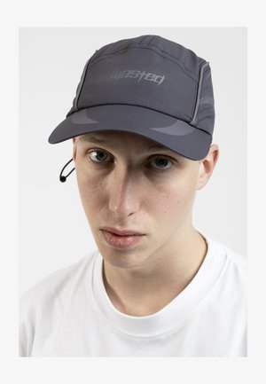 Gray cap with a curved brim, featuring a reflective logo and textured accents. Worn with a white t-shirt, displayed against a plain background.