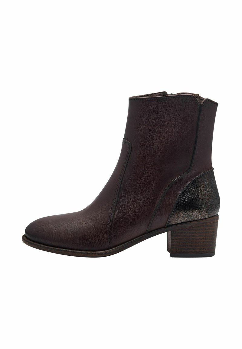 Botas de tobillo de cuero marrón con tacón cuadrado, que presentan un acento texturizado negro en la parte trasera y un zipper lateral para el cierre.