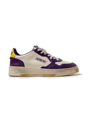 Sneaker bianca e viola a taglio basso con lacci, linguetta gialla sul tallone e logo "Autry" con bandiera americana sul lato.