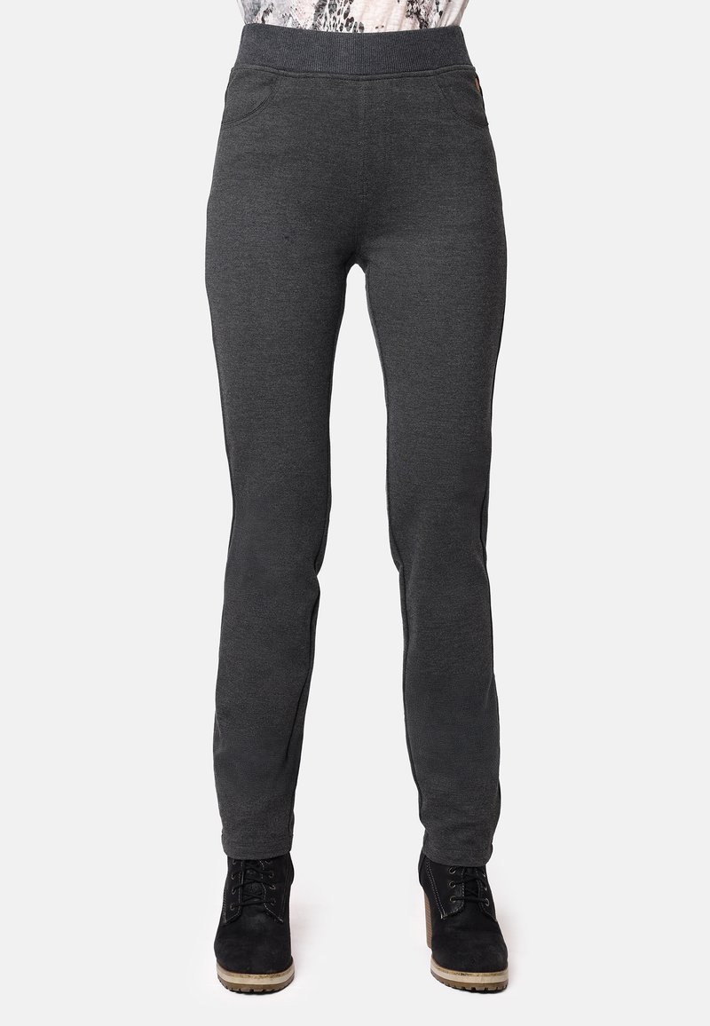 Pantalones de chándal grises con una textura suave, que presentan una cinturilla alta, bolsillos laterales y un diseño ajustado. Incluye un par de botas negras tipo tobillo.