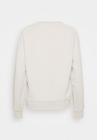 Mikina krémové barvy z měkkého materiálu, s jednoduchým designem, dlouhými rukávy a žebrovanými manžetami. Bez viditelných grafických prvků nebo vzorů.