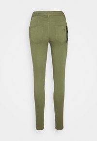 Olivgröna skinny jeans med mjuk textur, hög midja och två bakfickor. Har en märkeslapp på sidan.