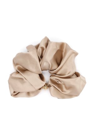 Béžová saténová scrunchie s hladkou, lesklou textúrou a malým zlatým krúžkom v záhyboch látky.