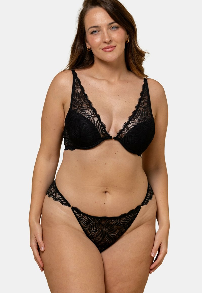 Ensemble de lingerie en dentelle noire comprenant un bralette en V avec des bretelles réglables et un string assorti avec un bord festonné et un motif floral.