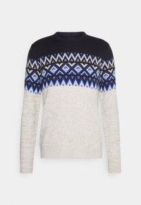 Sweter z okrągłym dekoltem, w niebieskiej górnej części, białej dolnej części oraz niebieskim, białym i czarnym geometrycznym wzorem na klatce piersiowej i rękawach.
