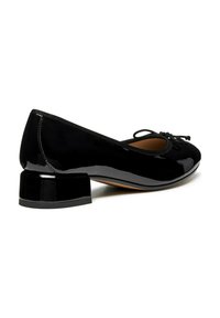 Bailarinas de charol negro con punta redonda, detalle de lazo delgado negro y tacón cuadrado grueso. Textura suave con acabado brillante.