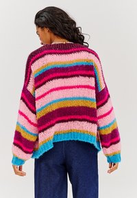 Wielokolorowy sweter z dzianiny z poziomymi paskami w kolorach różowym, fioletowym, niebieskim i brązowym; luźny krój z ściągaczami u dołu i na mankietach.