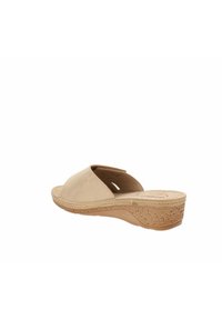 Sandalo con zeppa aperto beige, con upper in morbido camoscio, suola in sughero testurizzato e tacco moderato. Presenta fasce incrociate per un supporto extra.