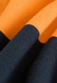 Gebreide stof met afwisselend oranje en donkerblauwe strepen. Gladde textuur met een zachte, lichte afwerking. Zichtbaar breipatroon.