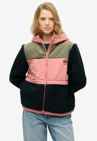 Hooded jack met een kleurblokontwerp in roze, groen en marineblauw. Heeft een ritssluiting en een pluizige textuur op het lichaam en de mouwen.