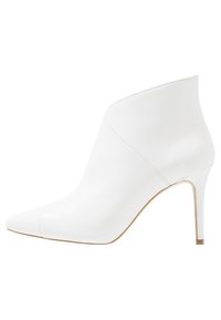 Białe skórzane botki za kostkę z wydłużonym noskiem, smukłym obcasem w kształcie szpilki i gładką fakturą. Charakteryzują się eleganckim, minimalistycznym designem bez widocznych elementów metalowych.
