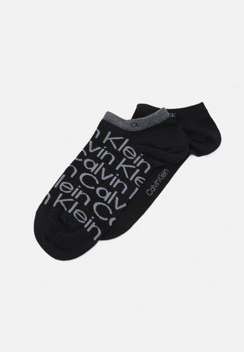 Calzini neri alla caviglia con motivo del logo grigio di Calvin Klein, realizzati in un materiale morbido e dotati di un polsino a coste grigio scuro in contrasto.
