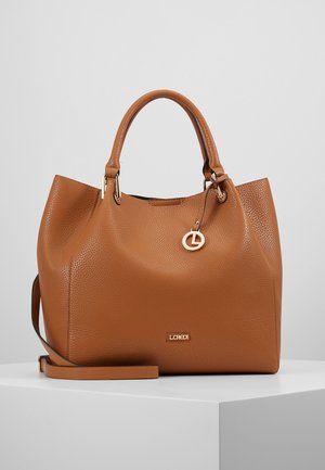 Sac à main en cuir texturé marron avec double poignée, une bandoulière amovible et un petit charme rond en or suspendu près du haut.