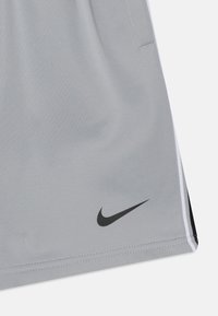 Szare krótkie spodenki sportowe z czarnym logo Nike Swoosh na krawędzi, z cienkimi białymi paskami po bokach i gładką, lekką fakturą materiału.