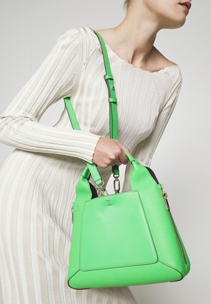 Grön läderhandväska med en strukturerad form, med guldfärgade detaljer och en avtagbar rem. Slät yta med kontrasterande svarta accenter.