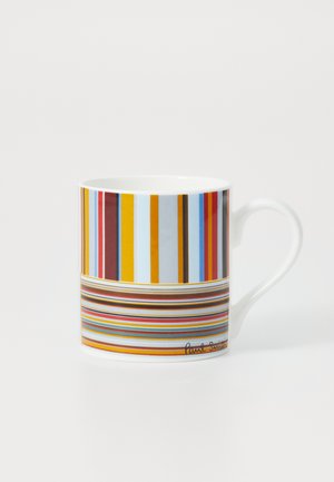 White porcelain mug featuring vertical and horizontal stripes in red, blue, yellow, and orange with a curved handle. Designer signature at base.