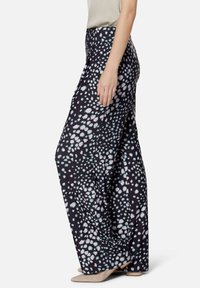 Black wide-leg trousers with a white and light blue spotted pattern. Made of lightweight fabric with a smooth texture, featuring a high waist.