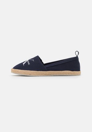 Espadrille bleu marine à enfiler avec semelle en jute et logo Calvin Klein Jeans sur le dessus, vue de côté.
