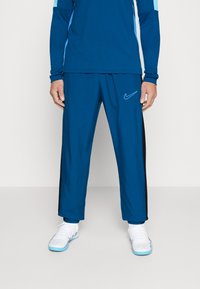 Nike Performance NIKE ACADEMY23 TRACK PANTS - Donji dijelovi trenirke - green abyss/black/baltic blue