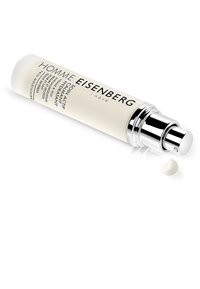 Vit cylindrisk flaska med silverpumpkork. Text på etiketten inkluderar "HOMME EISENBERG" och produktinformation. En liten klick kräm bredvid.