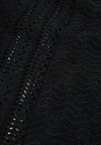 Tissu tricoté noir présentant un motif texturé avec des lignes ondulées et des détails en dentelle. Matériau doux et léger, étroitement tissé.