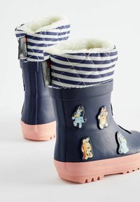 Stivali di gomma blu con suola rosa e rivestimento in peluche, caratterizzati da un motivo a righe in cima e adesivi di animali cartoon sui lati.
