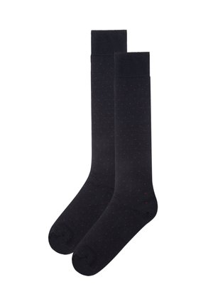 Knee-length black socks with a smooth texture, featuring a subtle pattern of small red polka dots throughout.