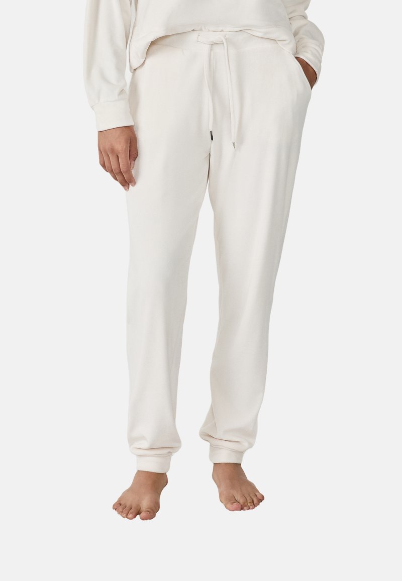 Pantalons de lounge blancs en coton avec une taille élastique et un cordon de serrage, dotés de poches latérales et de poignets ajustés aux chevilles.